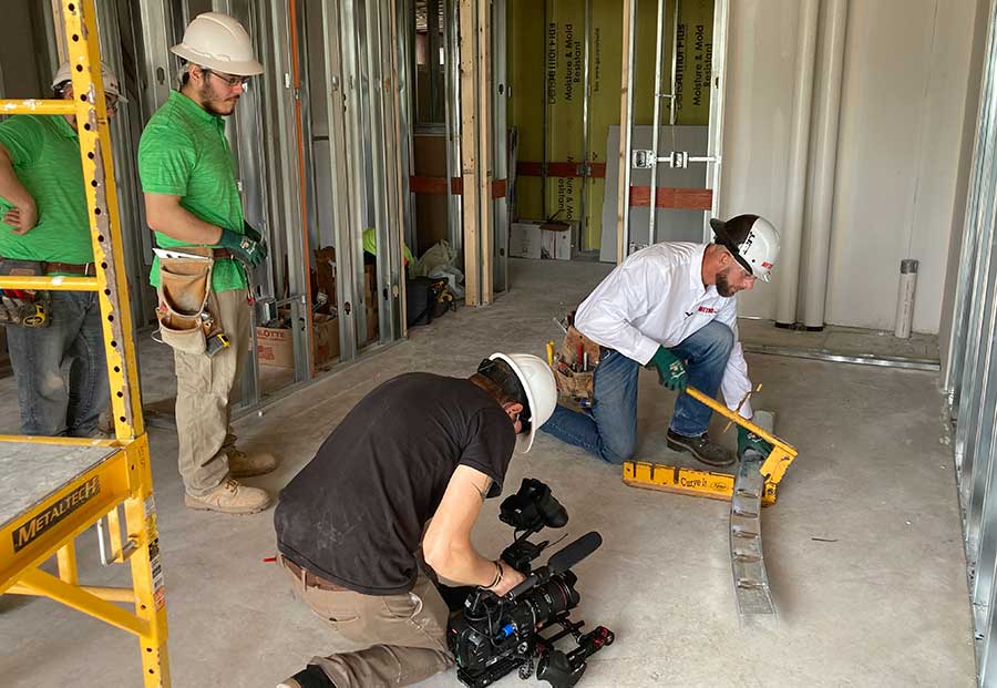 Colin Lane of Metro Walls demonstrates to his crew how to use a track bender.